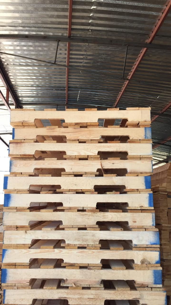 Tarimas industriales de madera apiladas al exterior